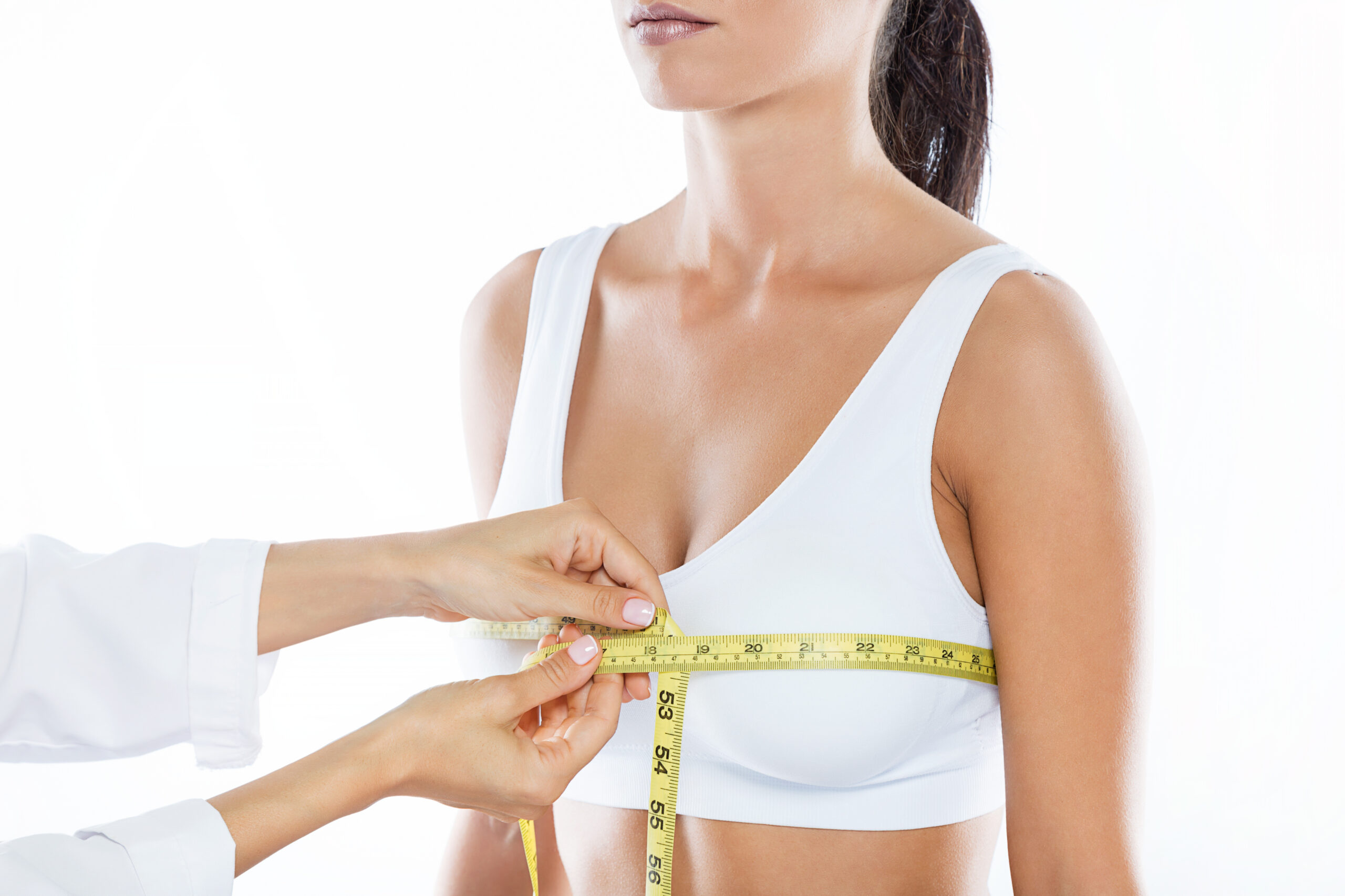 Doctor with measure tape measuring the size of the patient’s bre